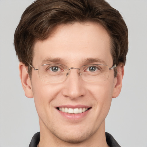 Joyful white adult male with short  brown hair and grey eyes