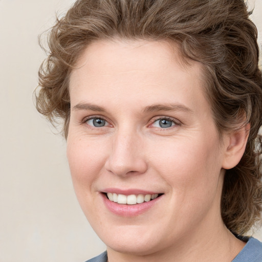 Joyful white young-adult female with medium  brown hair and blue eyes