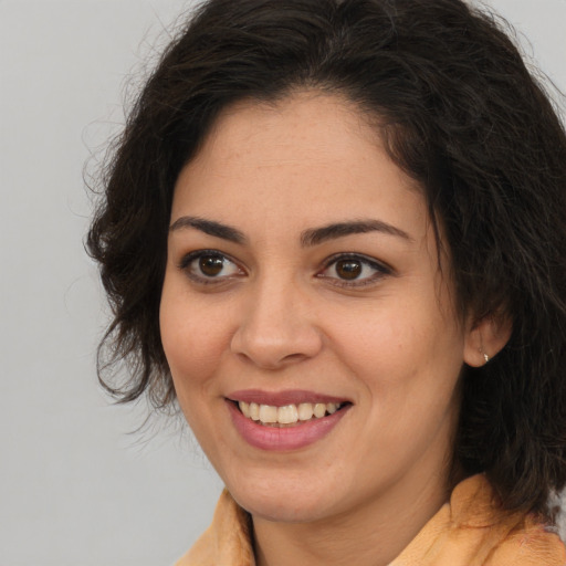 Joyful latino young-adult female with medium  brown hair and brown eyes