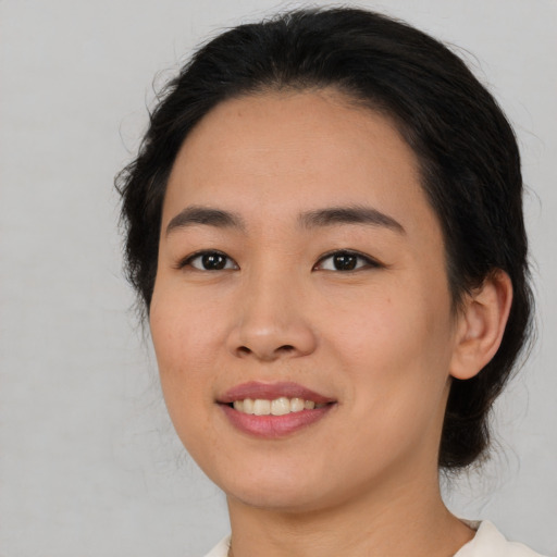 Joyful asian young-adult female with medium  brown hair and brown eyes