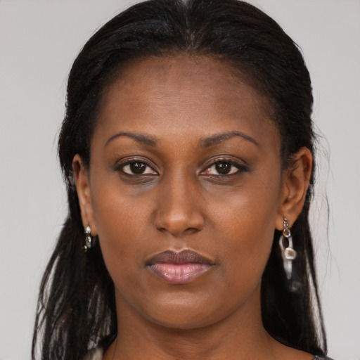 Joyful black young-adult female with long  brown hair and brown eyes