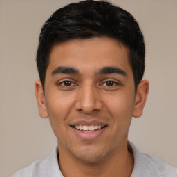 Joyful latino young-adult male with short  black hair and brown eyes