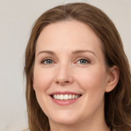 Joyful white young-adult female with long  brown hair and green eyes