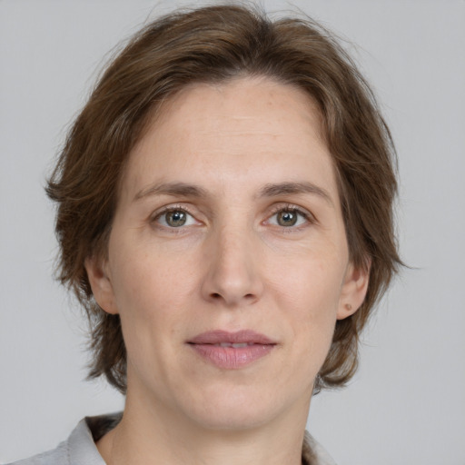 Joyful white adult female with medium  brown hair and grey eyes