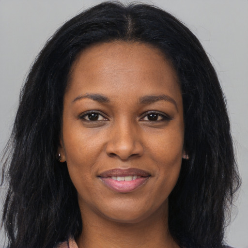 Joyful black young-adult female with long  black hair and brown eyes