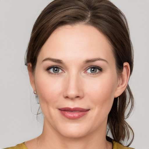 Joyful white young-adult female with medium  brown hair and grey eyes