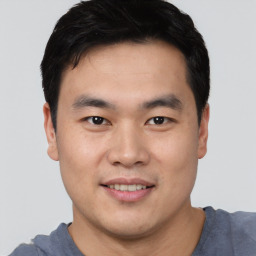 Joyful asian young-adult male with short  black hair and brown eyes