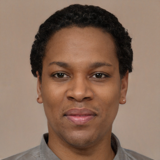 Joyful black young-adult female with short  black hair and brown eyes