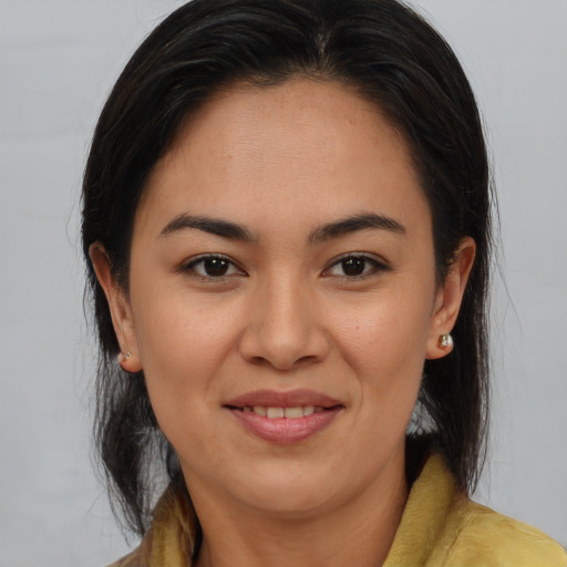 Joyful latino young-adult female with medium  brown hair and brown eyes