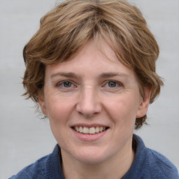 Joyful white adult female with medium  brown hair and blue eyes