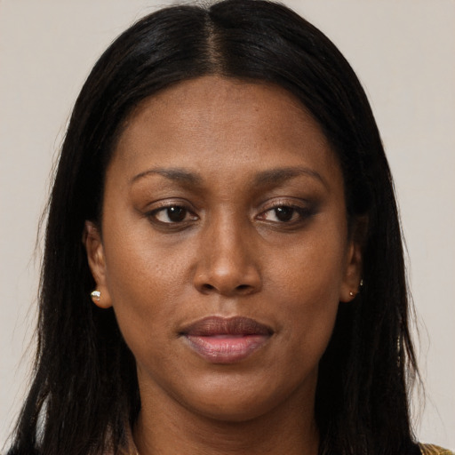 Joyful black young-adult female with long  brown hair and brown eyes