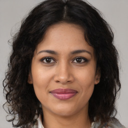 Joyful latino young-adult female with medium  brown hair and brown eyes