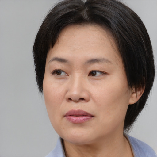 Joyful asian adult female with medium  brown hair and brown eyes