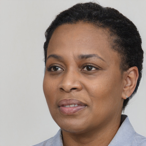 Joyful black adult female with short  black hair and brown eyes
