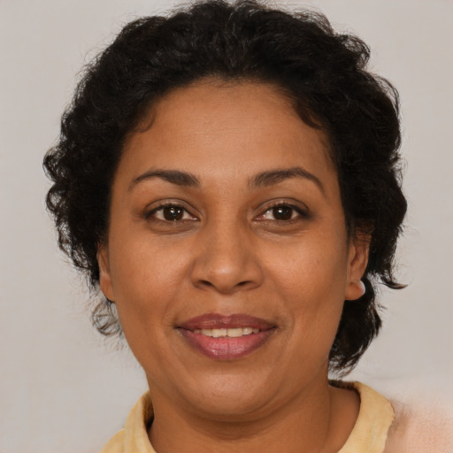 Joyful latino adult female with short  brown hair and brown eyes