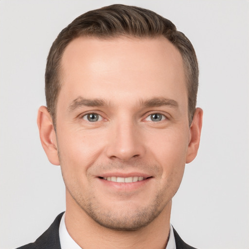 Joyful white young-adult male with short  brown hair and grey eyes