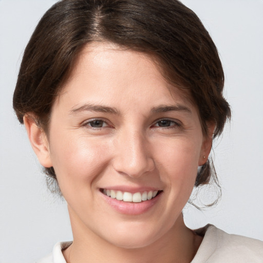 Joyful white young-adult female with medium  brown hair and grey eyes