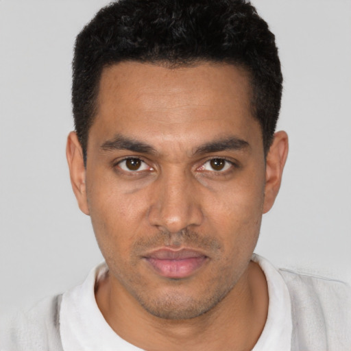 Joyful latino young-adult male with short  black hair and brown eyes