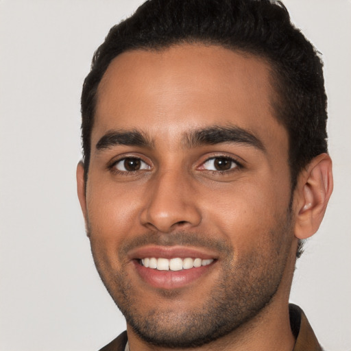 Joyful black young-adult male with short  brown hair and brown eyes