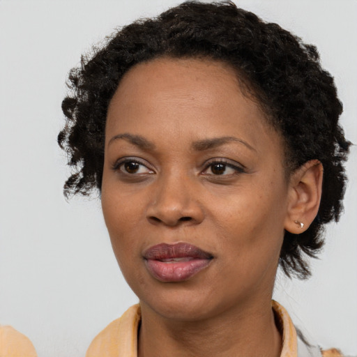 Joyful black adult female with short  brown hair and brown eyes
