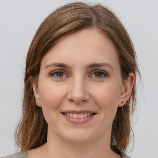 Joyful white young-adult female with medium  brown hair and grey eyes