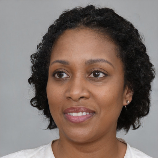 Joyful black young-adult female with medium  black hair and brown eyes