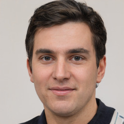 Joyful white young-adult male with short  brown hair and grey eyes