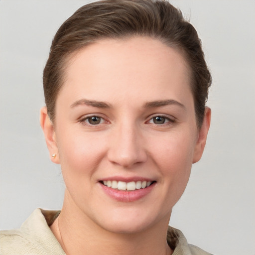 Joyful white young-adult female with short  brown hair and grey eyes