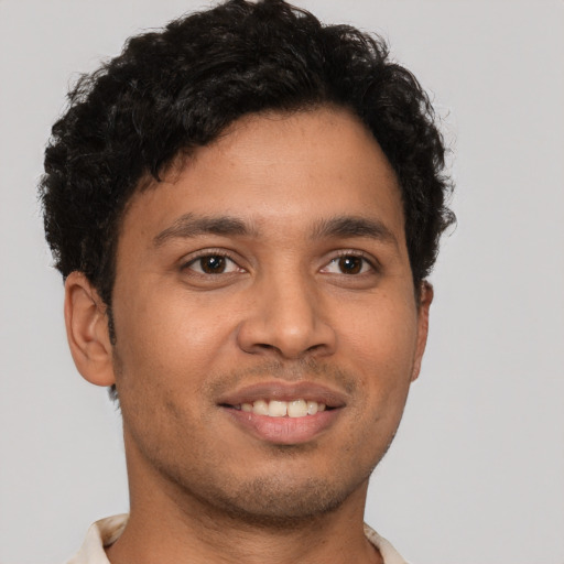 Joyful latino young-adult male with short  brown hair and brown eyes
