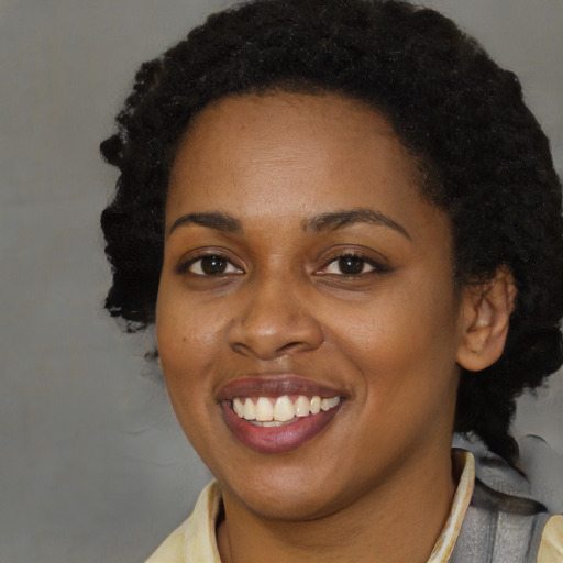 Joyful black adult female with short  brown hair and brown eyes
