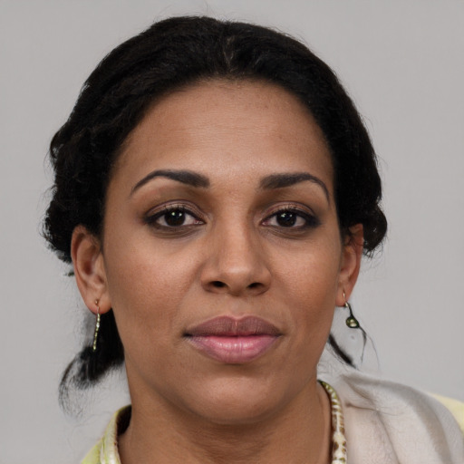 Joyful latino adult female with medium  brown hair and brown eyes