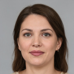 Joyful white young-adult female with medium  brown hair and grey eyes