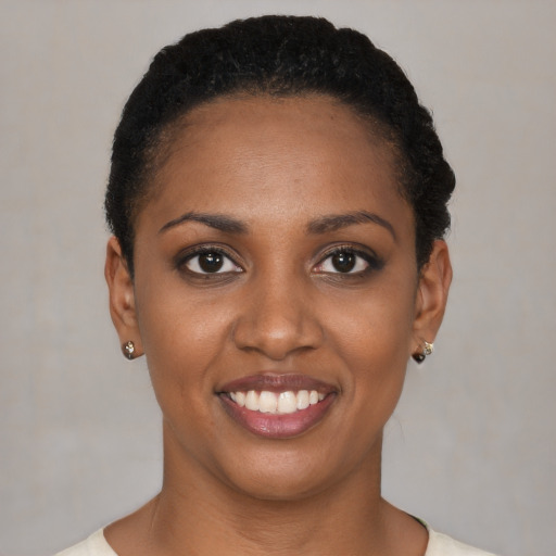 Joyful black young-adult female with short  black hair and brown eyes