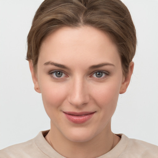 Joyful white young-adult female with short  brown hair and grey eyes