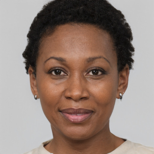 Joyful black adult female with short  black hair and brown eyes