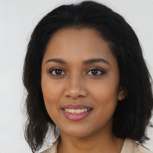 Joyful black young-adult female with long  brown hair and brown eyes