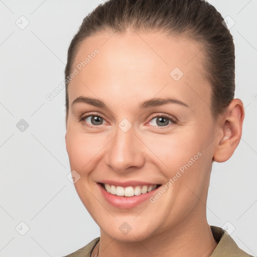 Joyful white young-adult female with short  brown hair and grey eyes