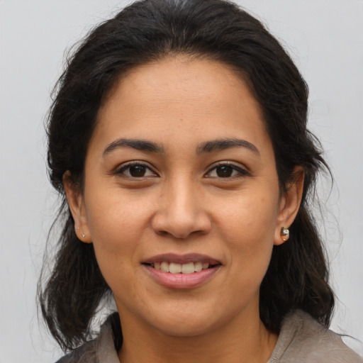 Joyful latino young-adult female with medium  brown hair and brown eyes