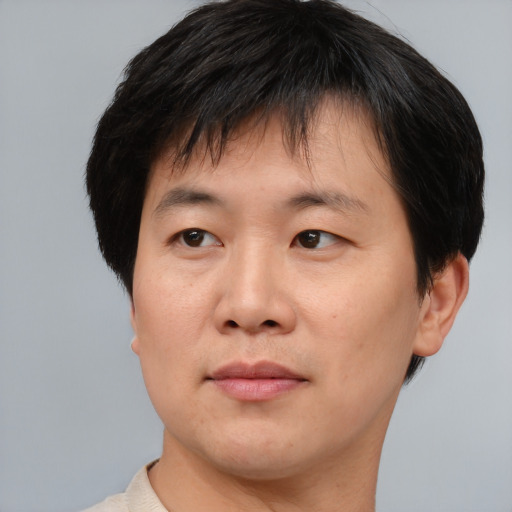 Joyful asian adult male with short  brown hair and brown eyes