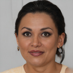 Joyful latino adult female with medium  brown hair and brown eyes