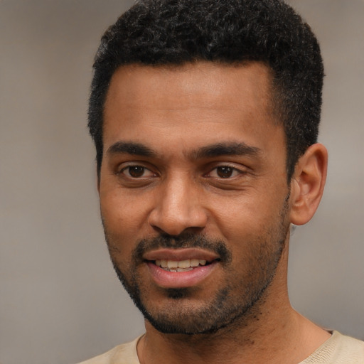 Joyful black young-adult male with short  black hair and brown eyes