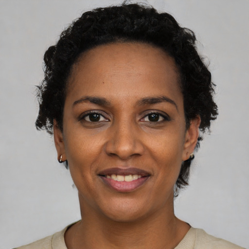 Joyful black young-adult female with short  black hair and brown eyes