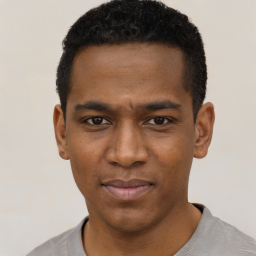 Joyful black young-adult male with short  black hair and brown eyes