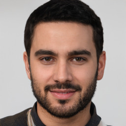 Joyful white young-adult male with short  black hair and brown eyes