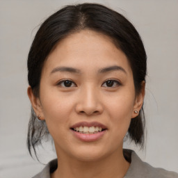 Joyful asian young-adult female with medium  brown hair and brown eyes