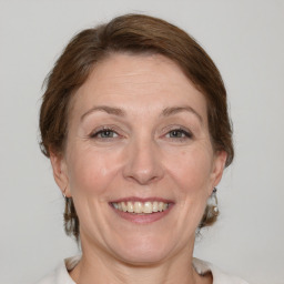 Joyful white adult female with medium  brown hair and grey eyes