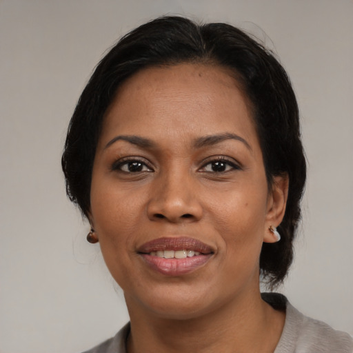 Joyful black adult female with medium  black hair and brown eyes