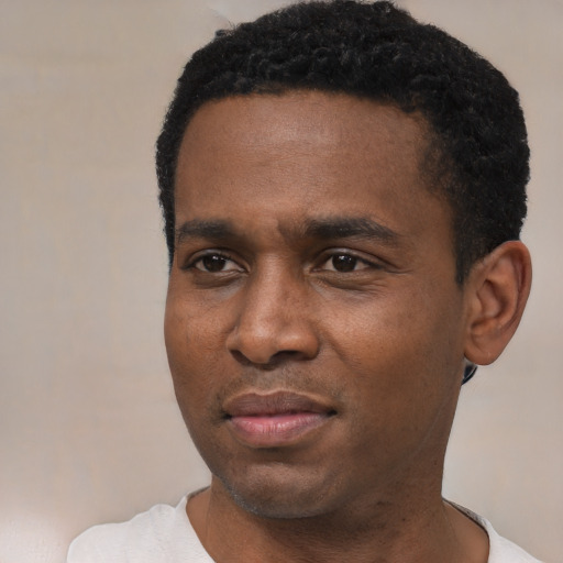 Joyful black young-adult male with short  black hair and brown eyes