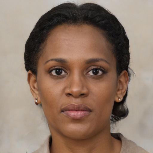 Joyful black young-adult female with short  brown hair and brown eyes