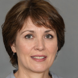 Joyful white adult female with medium  brown hair and grey eyes